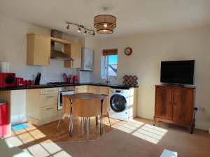 汤顿Central Taunton 2-bedroom apartment, great location!的厨房配有桌子和洗碗机。