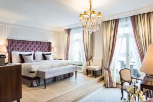 汉堡Fairmont Hotel Vier Jahreszeiten, Hotel des Jahres 2023 & 2024- Die 101 Besten的一间卧室配有一张大床和一个吊灯。