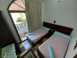 阿斯旺BAYT ZAINA - Nubian hospitality house的小房间设有两张床和窗户