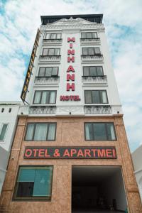 海防Minh Anh Hotel & Apartment的上面标有酒店标志的高大的白色建筑