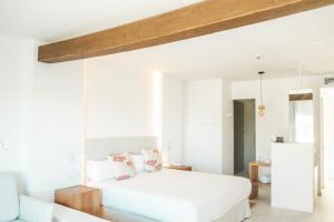 圣安东尼奥湾Hotel Boutique & Spa Las Mimosas Ibiza的卧室配有白色床和粉红色枕头