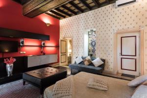 罗马NSM 71 Via del Corso Luxury Home的客厅设有红色的墙壁、一张沙发和一张桌子