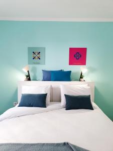 科拉雷侯Dimore Italiane - Boutique Apartments的卧室配有白色床和蓝色的墙壁