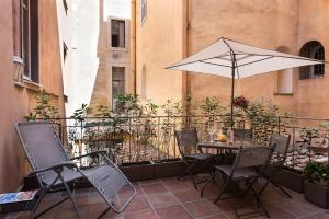 罗马NSM 71 Via del Corso Luxury Home的阳台配有桌椅和遮阳伞
