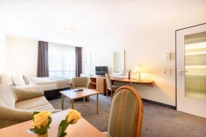 莱比锡acora Leipzig Living the City的酒店客房设有床和客厅。