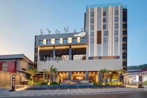 三宝垄Hotel Aruss Semarang的一座棕榈树环绕的大建筑