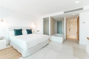 圣安东尼奥湾Hotel Boutique & Spa Las Mimosas Ibiza的白色卧室设有一张大床和浴缸