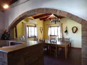 Salto de las RosasTree House Hostel的厨房以及带桌椅的用餐室。