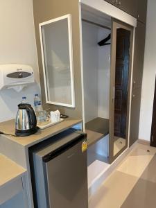 Sinsiri hostel的一间带冰箱和镜子的小厨房