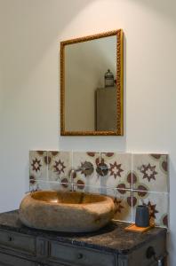 茹卡La Bastide Neuve的一间带石制水槽和镜子的浴室