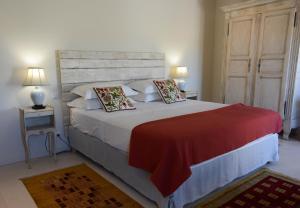 茹卡La Bastide Neuve的一间卧室配有一张带红色毯子的大床