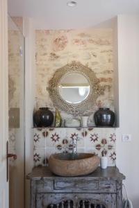 茹卡La Bastide Neuve的浴室设有水槽和墙上的镜子