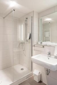 莱茵河畔威尔Maximilian Hotel & Apartments Weil am Rhein / Basel的带淋浴和盥洗盆的白色浴室