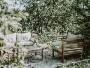胡法利兹Wooden Soul : duplex 2 chambres avec jardin commun的两把椅子和一张沙发,在树前