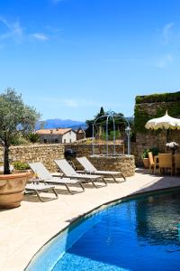 Santa-Reparata-di-BalagnaCASA SANTA MARIA的一座带躺椅的游泳池,毗邻石墙