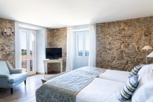 Santa-Reparata-di-BalagnaCASA SANTA MARIA的一间卧室设有一张大床和石墙