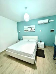 奇尼斯B&B Santorini的卧室配有白色的床和蓝色的墙壁
