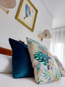 阿拉萨特-蒙德拉贡Pension Uxarte的一张带两个蓝色枕头的床和一张墙上的照片