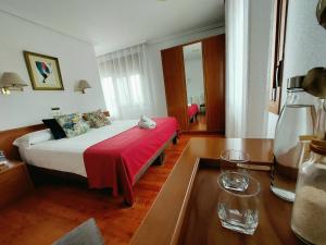 阿拉萨特-蒙德拉贡Pension Uxarte的酒店客房,配有一张带红色毯子的床