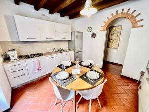 贝加莫[Art of Bergamo] Luxury & design house的厨房配有木桌和白色橱柜。