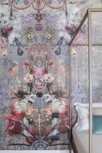 巴勒莫Vossia Luxury Rooms & Sicilian Living的卧室的墙上装饰有花卉图案的壁纸
