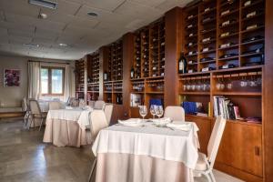 阿尔的伊索Hotel La Vida Spa的用餐室配有2张桌子和葡萄酒瓶