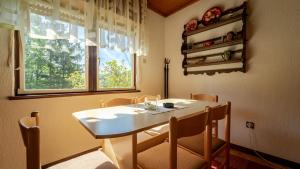 代尔尼采Holiday house with a parking space Lokve, Gorski kotar - 18226的一间带桌椅和窗户的用餐室