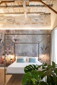 巴勒莫Vossia Luxury Rooms & Sicilian Living的卧室配有一张大床,墙上挂有绘画作品