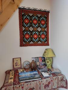 梅斯蒂亚Village House的一张桌子,墙上挂着书和照片