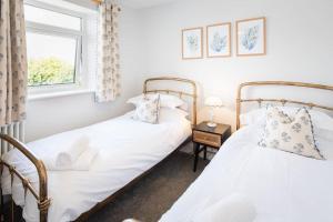 托基*Brand New* Olive Grove Cottage的带窗户的客房内设有两张单人床。