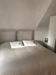 因普鲁内塔波吉农庄酒店的一张位于小房间的床,配有白色床罩