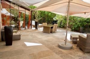奥佩德LASUITE Domaine Bertuli, heated Pool, Aircon的庭院配有遮阳伞和桌椅。