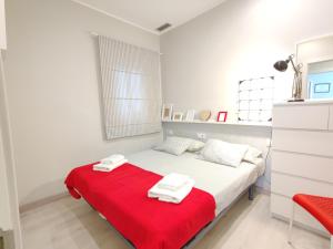 巴塞罗那Fira Plaza España apartment的一间白色卧室,床上铺有红色毯子