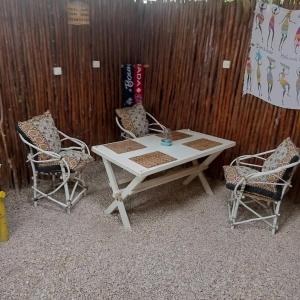 南威卡洛塔民宿的一张白色的桌子和两把椅子以及木墙