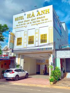 波来古市Hà Anh Hotel的停在大楼前的白色汽车