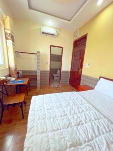 波来古市Hà Anh Hotel的卧室配有一张白色大床和一张书桌