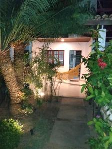 萨尔瓦多Casa em Village com piscina e perto da praia的前面有棕榈树的房子