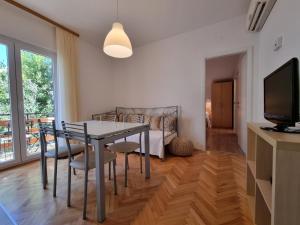 杜埃Apartments by the sea Duce, Omis - 2821的一间带桌椅和电视的用餐室