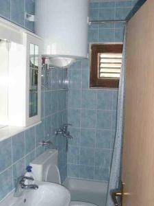 苏提万Double Room Sutivan 2943b的蓝色瓷砖浴室设有水槽和浴缸