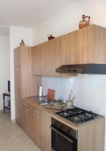 苏佩塔尔Apartments with a parking space Supetar, Brac - 2850的厨房配有木制橱柜和炉灶烤箱。