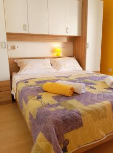 波尔Apartments with a parking space Bol, Brac - 2890的一间卧室配有一张黄色和紫色毯子的床
