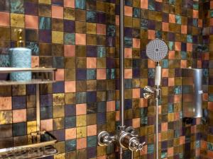 维尼察Vinica Castle的浴室里设有淋浴,铺有色彩缤纷的瓷砖