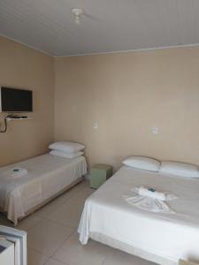 佩尼亚Hospedagem Quinta do Correia的一间酒店客房,设有两张床和电视