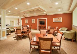 雷丁雷丁假日酒店的餐厅设有木桌、椅子和平面电视。
