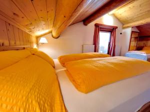 利维尼奥Garni Francescato的配有黄色床单的客房内的两张床