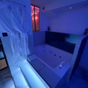 奥贝维利埃Le BLUE的带浴缸和蓝色灯光的大浴室