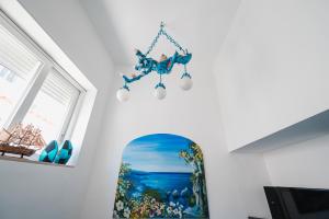 阿纳卡普里B&B La Bella Annacapri的挂在墙上的吊灯,挂着一幅画