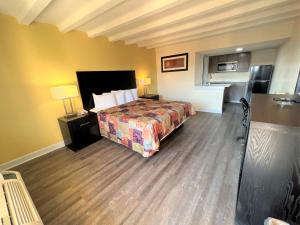 纽波特纽斯James River Inn & Suites的酒店客房,设有一张床,铺有木地板
