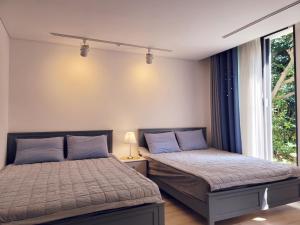 木浦市Gallery Family Hotel的一间卧室设有两张靠窗的床。