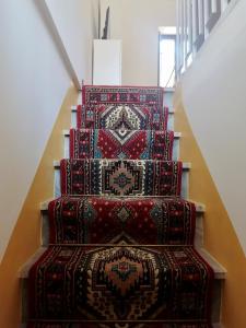 切拉诺B&B Nonno Loreto的一套三层楼梯的立柱,上面有地毯